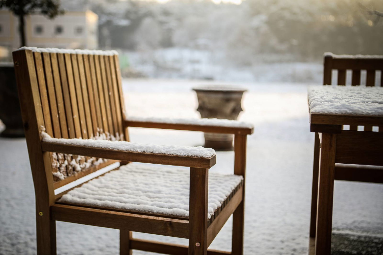 Schneebedeckte Holzbank im Garten