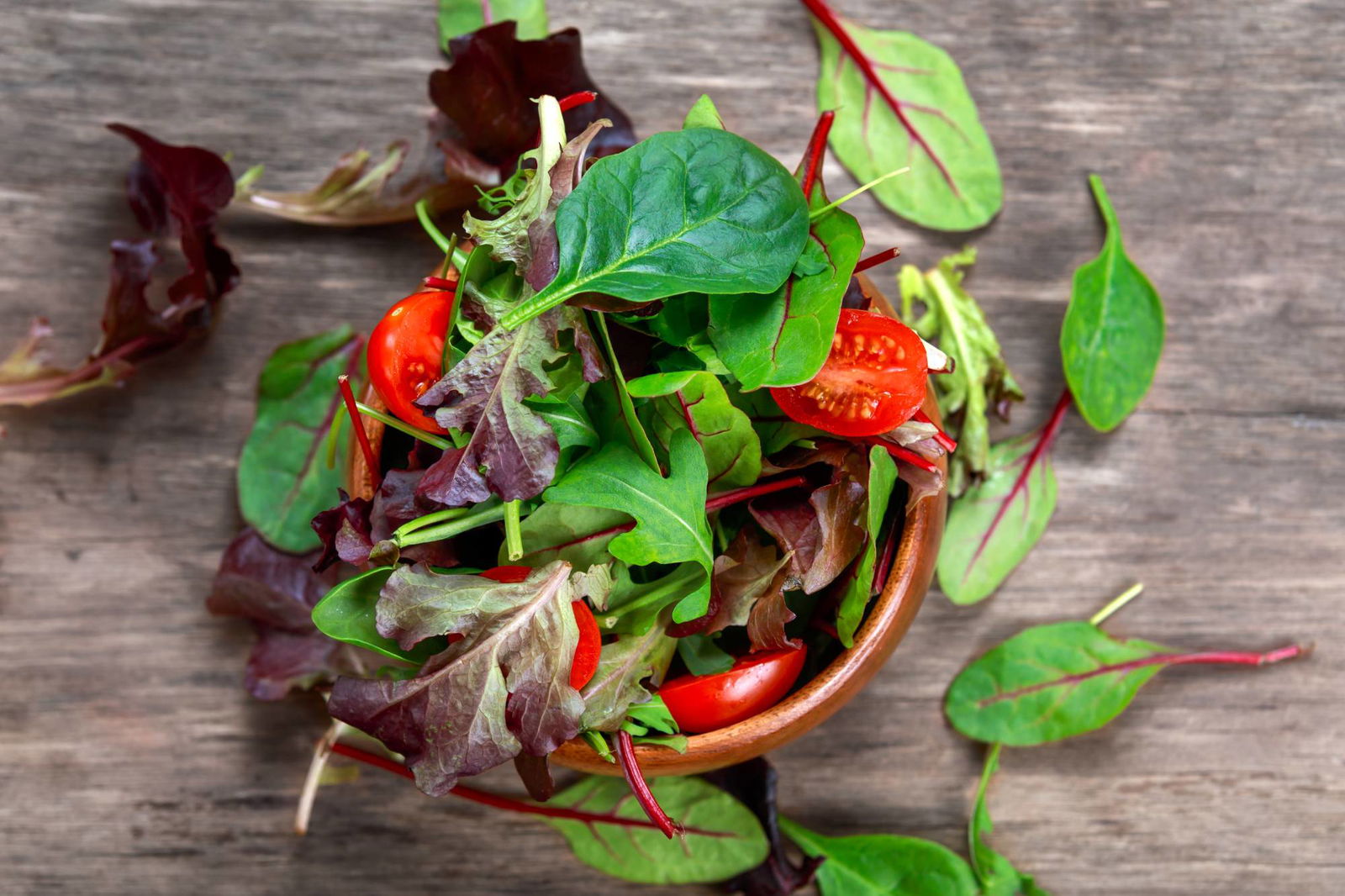 Fitnesssalat mit Rucola, Spinat, Tomaten in Holzschale